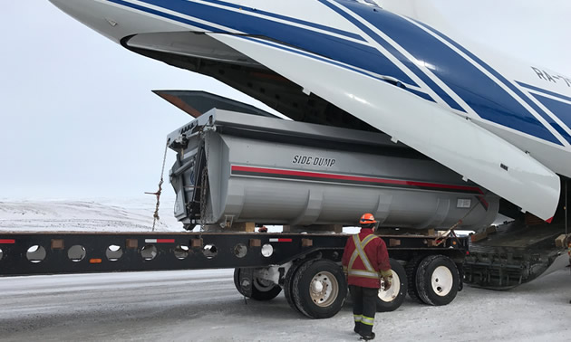 Truck being loaded into airplane.