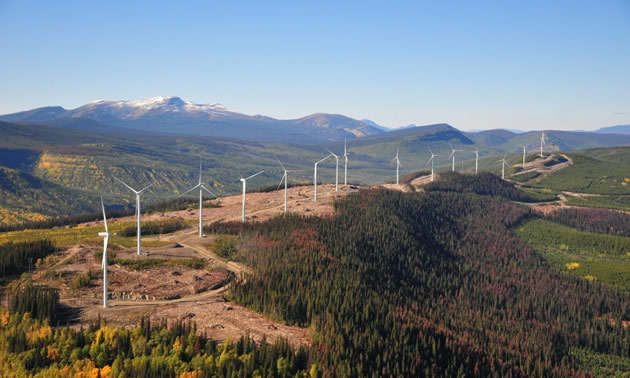 Hillside with row of wind turbines.