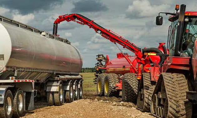 Truck transferring biosolids into tanker.
