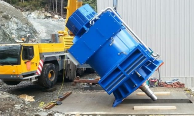 Truck unloading large machinery.