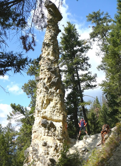 Madu stands next to a remnant erosional feature, where the cap rock protects the underlying materials from being eroded away, near Pillar Lake in southern B.C.