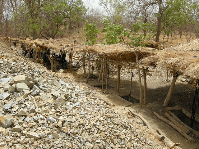 Makeshift shelters cover shafts dug by hand along a vein by artisanal miners in Senegal. Rhys.
