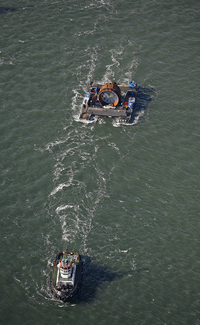Tugboats pull a barge containing the OpenHydro turbine into position near Parrsboro, Nova Scotia, in November 2009.