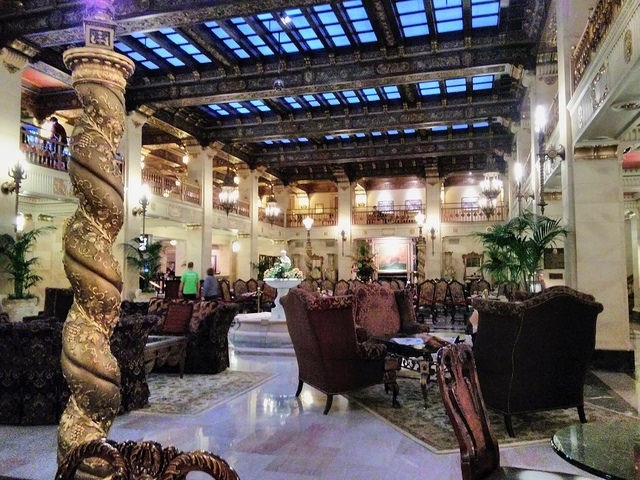 The glassed roof courtyard decorated with large comfortable arm chairs, persian rugs and a central fountain in the historic and uniquely beautiful Davenport Hotel in downtown Spokane, Washington.